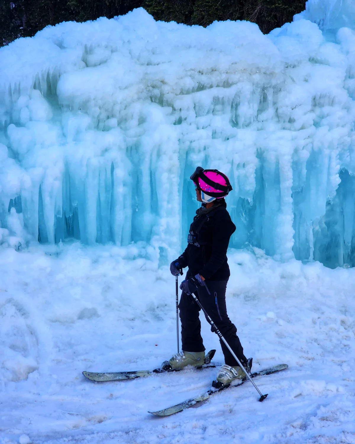The founder of The Brag Route on skis beside a frozen waterfall in Gulmarg