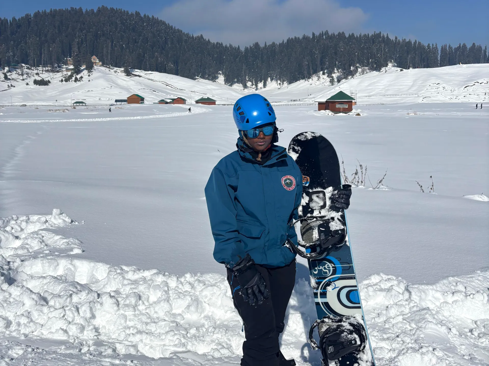 A snowboarder with her board in Gulmarg